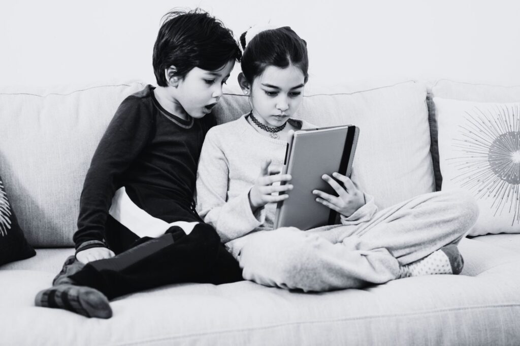 Siblings play on a tablet together